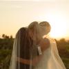 Gli sposi si baciano sotto il velo nella luce del tramonto, durante la sessione fotografica di matrimonio.