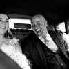 La sposa e suo padre ridono insieme in auto, durante il viaggio verso la cerimonia.